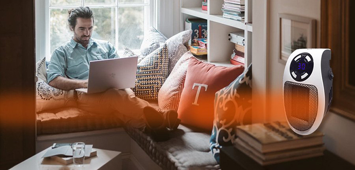 man getting warm in his living room with Hero Heater